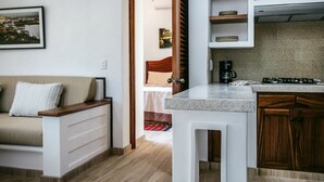 A compact living space with a kitchenette, a sofa, and a dining area.