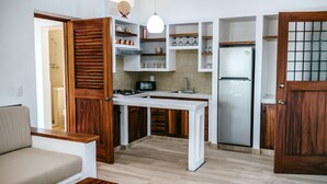 A compact kitchen with wooden cabinets, a built-in stove, and a refrigerator.