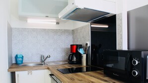 A modern kitchen with a wooden countertop, a black microwave, a coffee maker, and a sink. - "All Baigne" - 1CH apartment with loggia closed sea panorama (Quiberon)