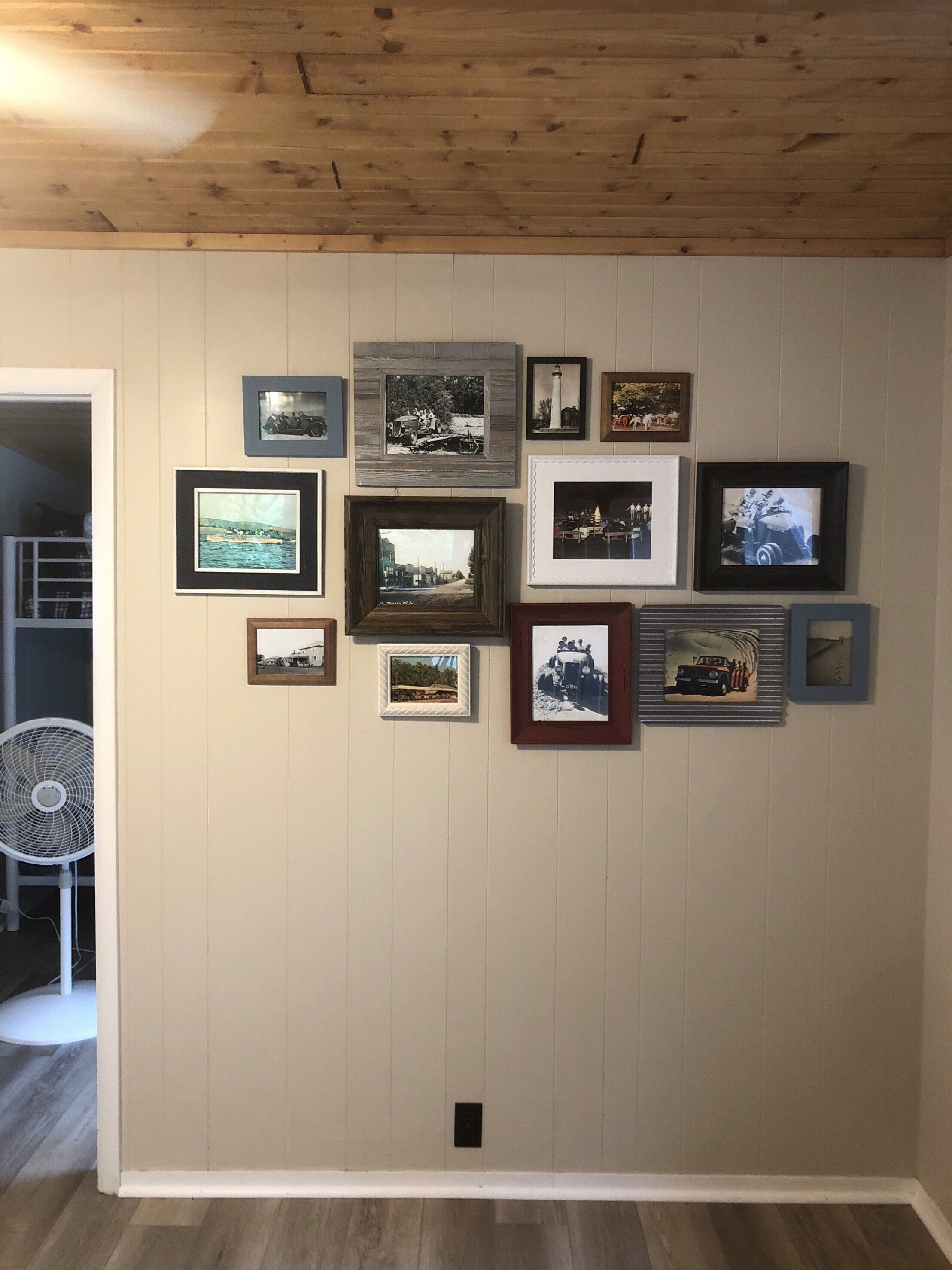 Un mur orné de plusieurs photographies encadrées, disposées selon un motif en forme de grille.