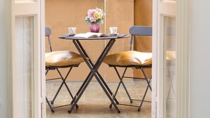A small table with two chairs, a vase with flowers, and two cups on a balcony. - Lovely New home, via Nazionale . (Roma)