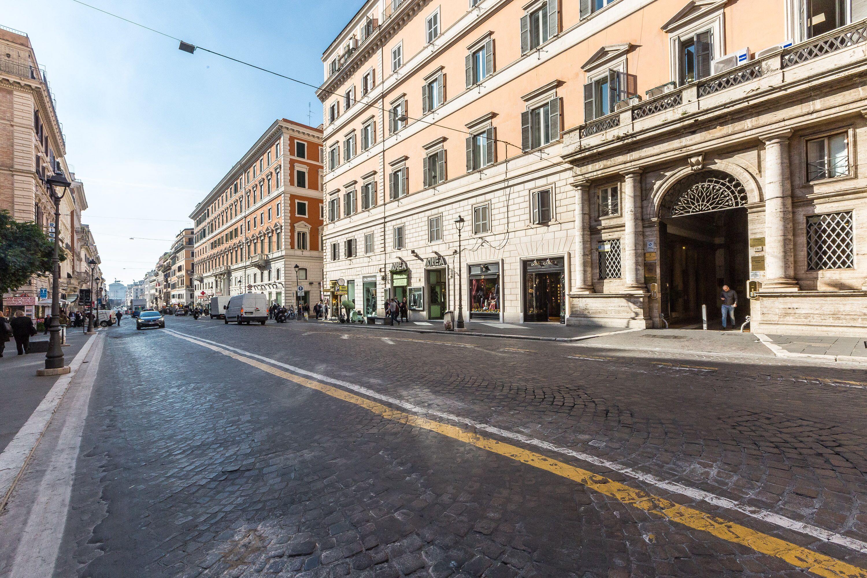 Una calle adoquinada flanqueada por edificios históricos, con un arco de entrada destacado.