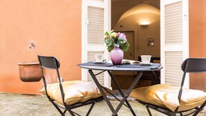 An outdoor seating area with a round table, two chairs, a potted plant, and a book. - Lovely New home, via Nazionale . (Roma)