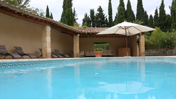 A swimming pool with lounge chairs and an umbrella. - 360 m2 house (Meynes)