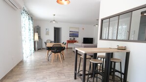 A modern living space with a dining area, kitchen, and seating area.
