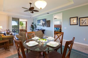 A dining area with a round glass table set for four, surrounded by wooden chairs. - Hilton Waikoloa Pool Pass for stays in 2026. Waikoloa Beach Villas M33 (Waikoloa Village)
