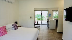 A hotel room with a bed, a small table, a desk, and a TV. - AQUA GUESTHOUSE 3~ STEPS FROM THE BEACH ~ POOL ~ A+ INTERNET (Puerto Morelos,)