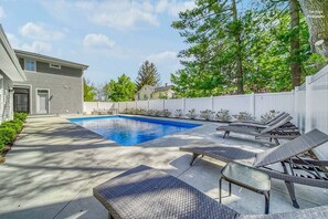A backyard with a swimming pool, lounge chairs, and a white fence. - Alex`s Pool House Private Pool & Hot Tub Centrally Located in the Saugatuck Douglas Area (Douglas)