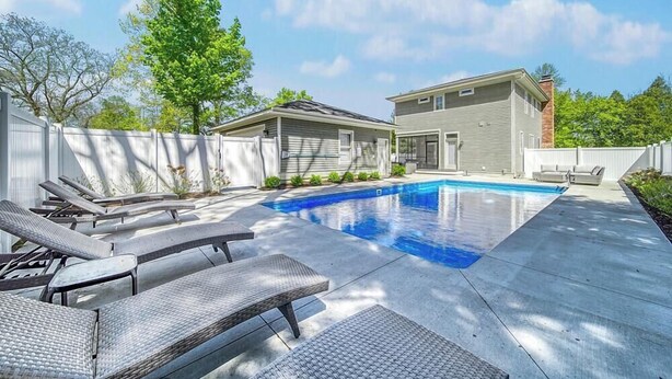 A backyard with a swimming pool, lounge chairs, and a house. - Alex`s Pool House Private Pool & Hot Tub Centrally Located in the Saugatuck Douglas Area (Douglas)