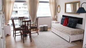 A bedroom with a bed, a desk, a chair, a lamp, and a window with curtains. - ELEGANT 1BED APARTMENT 50 METRES FROM PLAYA DE LOS INGLESES (Punta del Este)