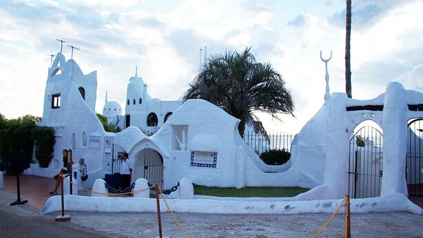 A white, whimsical building with arched windows and a palm tree in front. - ELEGANT 1BED APARTMENT 50 METRES FROM PLAYA DE LOS INGLESES (Punta del Este)