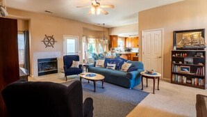 A cozy living room with a sofa, armchairs, a coffee table, and a bookshelf. - Ione Captains Cottage With 3 separate BEDROOMS Close to Town. Centrally located. (Ione)