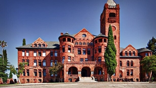 A large, red brick building with a prominent tower and arched windows. - Ione Captains Cottage With 3 separate BEDROOMS Close to Town. Centrally located. (Ione)