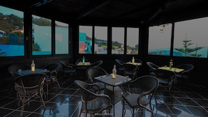 A restaurant with outdoor seating, tables, chairs, and bottles of drinks. - Hotel Ziryab (Chefchaouen)