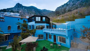 A blue building with a balcony and outdoor seating area. - Hotel Ziryab (Chefchaouen)