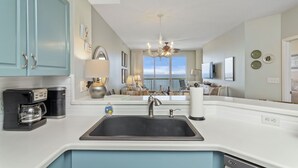 Een moderne keuken met een grote spoelbak, een koffiezetapparaat en een vaatwasser.