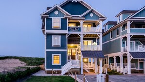 A two-story building with a balcony and a sign that reads "Ocean Star." - 5410- Ocean Star - Oceanfront Nags Head Luxury Home w/ Pool (Nags Head)