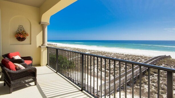 A balcony with wicker furniture and a view of the beach. - Gulf Front Luxury - Private Elevator/5 Master bdrms - each w/private bath  (Navarre)