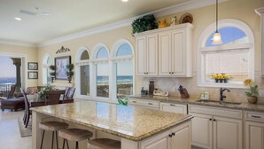 A spacious kitchen with a large island, white cabinetry, and a view to the outside. - Gulf Front Luxury - Private Elevator/5 Master bdrms - each w/private bath  (Navarre)
