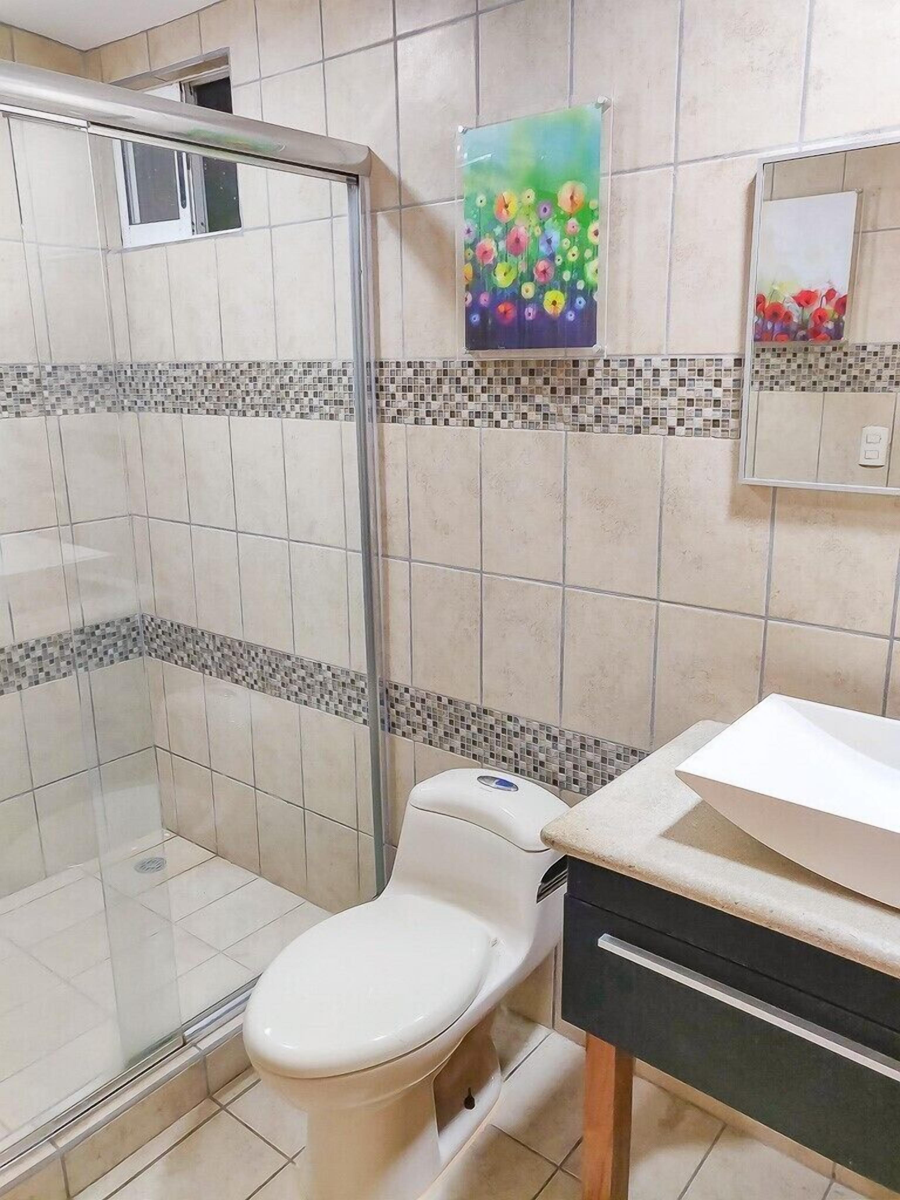 Un bagno con doccia, toilette e lavandino.