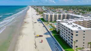 A coastal hotel with a beachfront view, multiple balconies, and a pool area. - BREATHTAKING OCEAN VIEWS & UPDATED CONDO  (New Smyrna Beach)