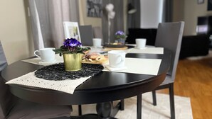 A dining table with a placemat, a potted plant, and a tray of pastries. - Heart of Downtown Edmonton, walking distance to Rogers Place / LRT station  (Edmonton)