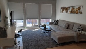 Un salon moderne avec un canapé, une table basse et un ventilateur de plafond.