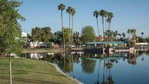 Un cadre paisible au bord du lac, avec un quai, des palmiers et un espace de repos abrité.
