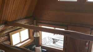 A cozy cabin interior with a loft bedroom, a dining area, and a kitchen. - Rustic cabin hidden among the pines. (Condon)