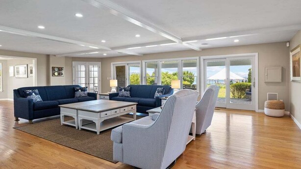 A spacious living room with a sectional sofa, a coffee table, and a striped armchair.