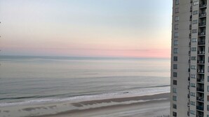 A high-rise building overlooking a beach with a clear sky. - Beautiful oceanview 1 bedroom with king bed, full kitchen, and water amenities  (Myrtle Beach)