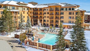 A multi-story hotel with a pool area, outdoor seating, and snow-covered surroundings. - Perfect summer! Balcony with views of the concerts, outdoor swimming pool, golf hiking and more (Park City)