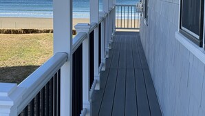 A covered porch with a view of the beach. - Brand new Five bedroom beachfront home on Moody Beach...Amazing location! (Wells)