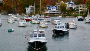A marina with various boats docked, surrounded by houses with autumn foliage. - Brand new Five bedroom beachfront home on Moody Beach...Amazing location! (Wells)
