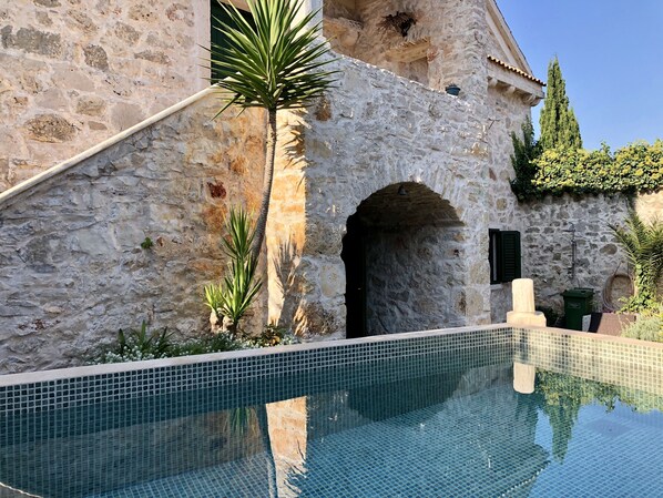 En säsongsöppen utomhuspool och solstolar