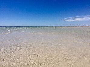A wide sandy beach with clear blue water and a distant shoreline. - Refurbished miners cottage 5 min from Moonta Bay + free internet (Moonta)
