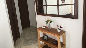 A hallway with a wooden console table, a mirror, and a door. - Canção Nova / Vacation home in Lavrinhas, SP, near Canção Nova.  (Lavrinhas)