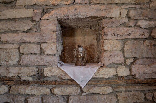 A stone wall with a lantern placed on a cloth. - Hotel Kalemi (Gjirokastër)