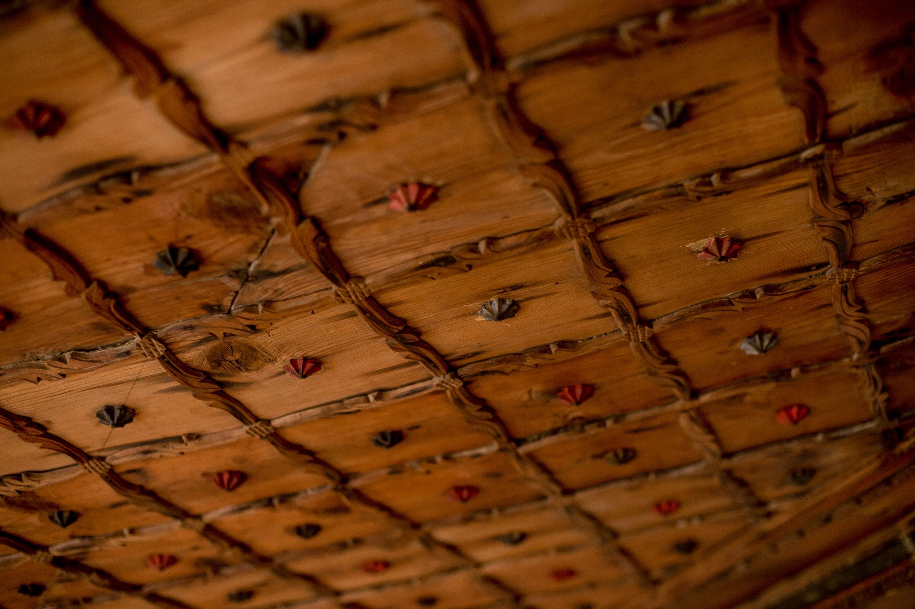 Um close-up de teto de madeira com padrão quadriculado e detalhes decorativos.