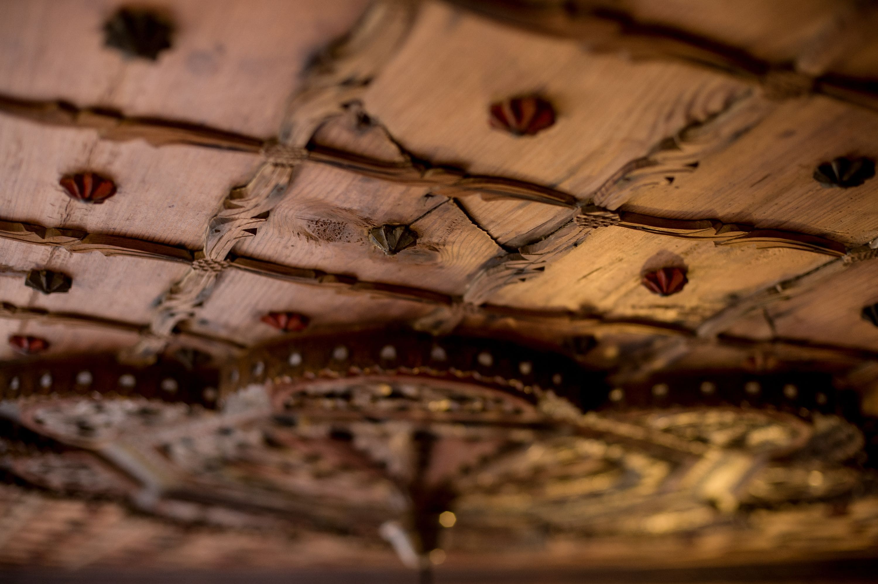 A close-up of a wooden surface with a woven pattern and metallic elements.