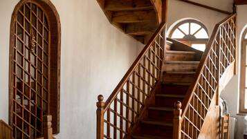 A wooden staircase with a railing, leading to an upper floor.