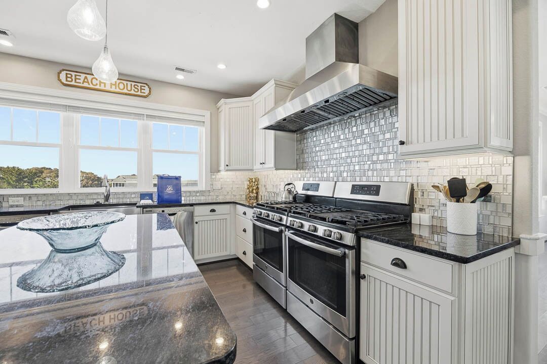 Een koelkast met diepvriezer, een microgolfoven, een oven, een kookplaat