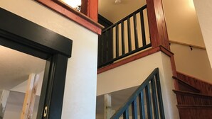 Una scala con ringhiere e corrimano in legno che conduce a un piano superiore.