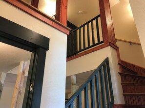 A staircase with wooden railings and a handrail, leading to an upper floor.