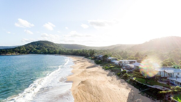 Um imóvel à beira-mar, com piscina e vista para o mar e as colinas.