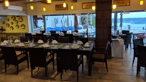 A restaurant with tables set for dining, a view of the beach, and a sign reading "BISTRO". - Beachfront resort in best location, walk to best clubs and restaurants (Cancún)