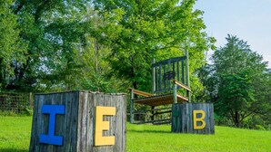 A wooden structure with large letters I, E, and B. - Tree Fort Balcony Suite (Springfield)