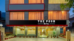 A hotel with a modern facade, multiple balconies, and a well-lit entrance. -  The Posh Hotel near Mall Road with Hassle Free Covered Parking (Dharamshala)