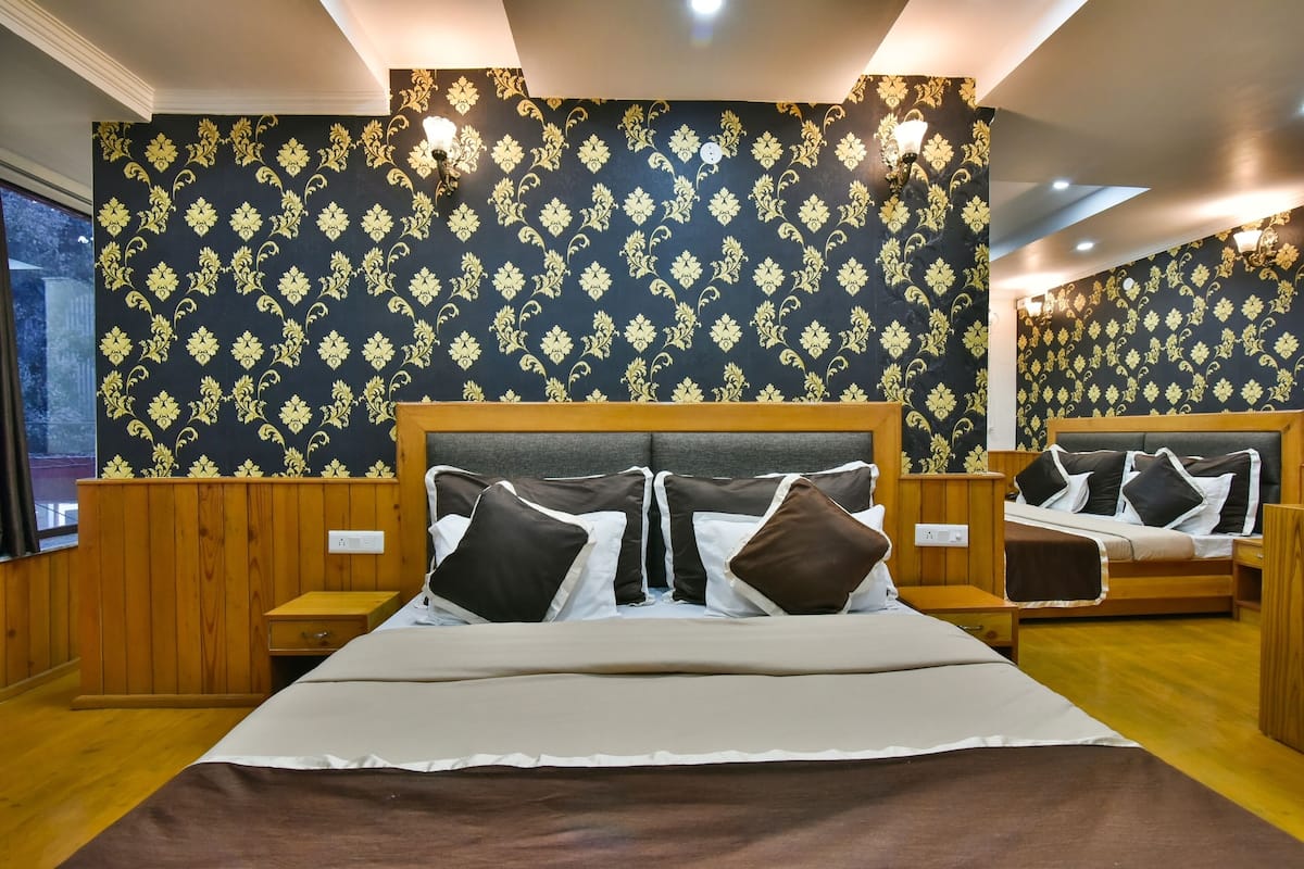 A hotel room with a large bed, wooden headboard, and a mirror.