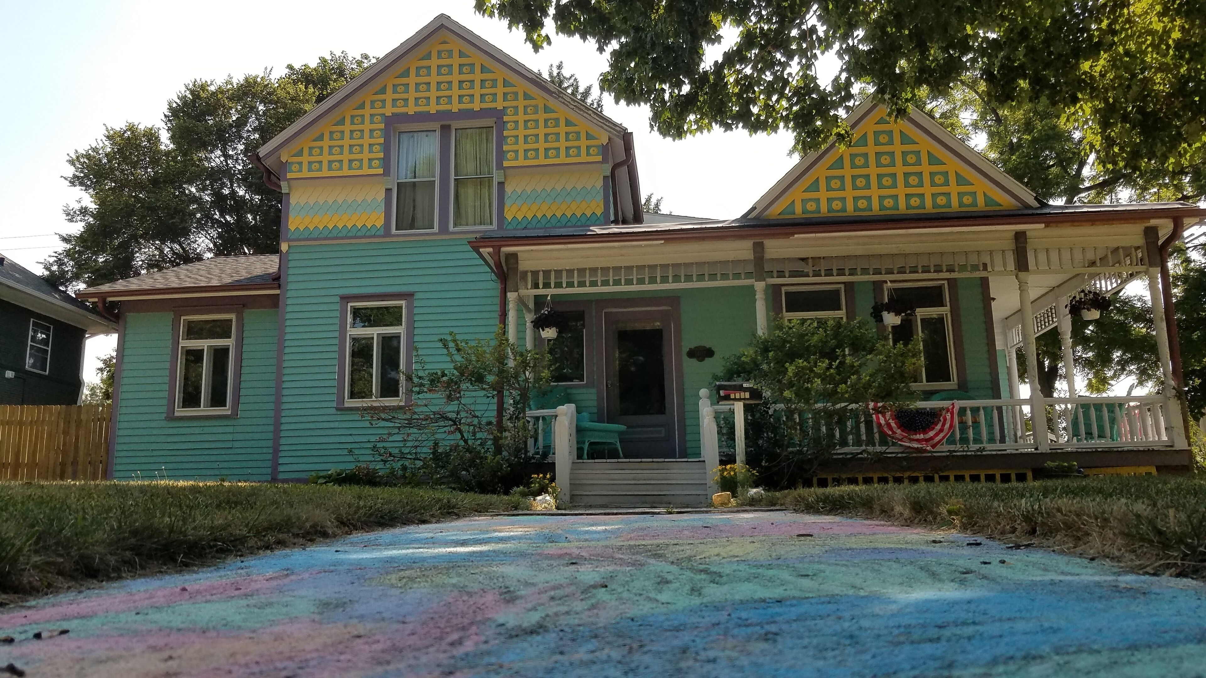 A two-story house with a porch and a front yard.